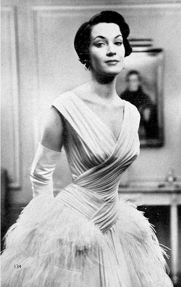 1953 British actress Jean Lodge wearing white draped chiffon gown adorned  with maribou feathers