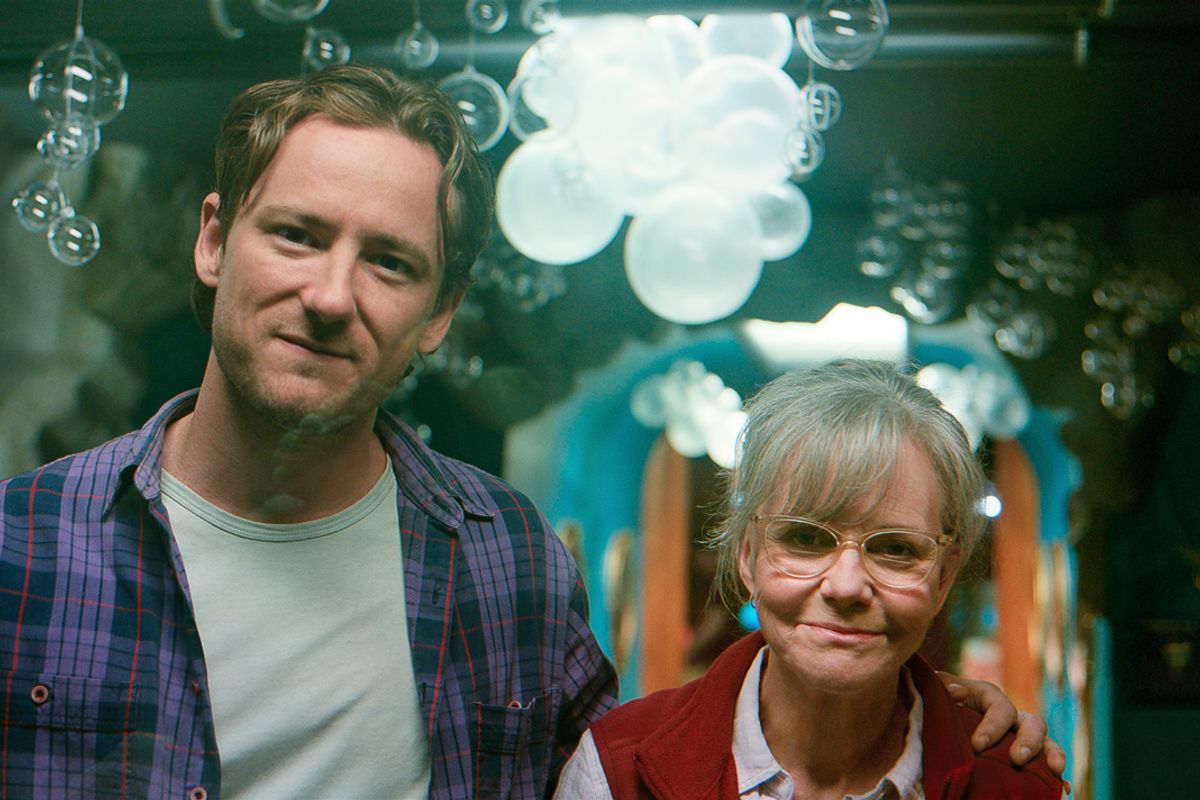 A man and a woman smile 