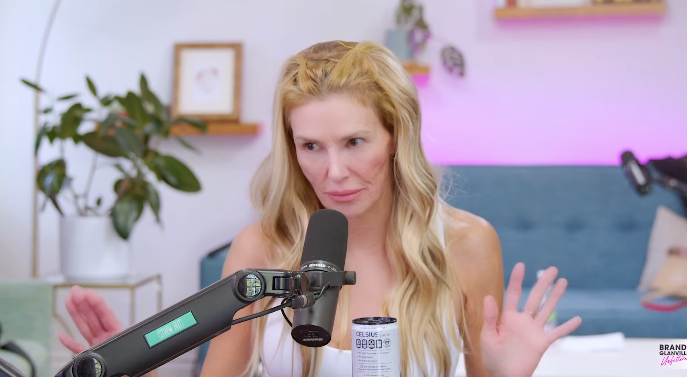 Brandi Glanville with a microphone and a can of Celsius drink, discussing her "sexually transmitted ringworm" in her throat.