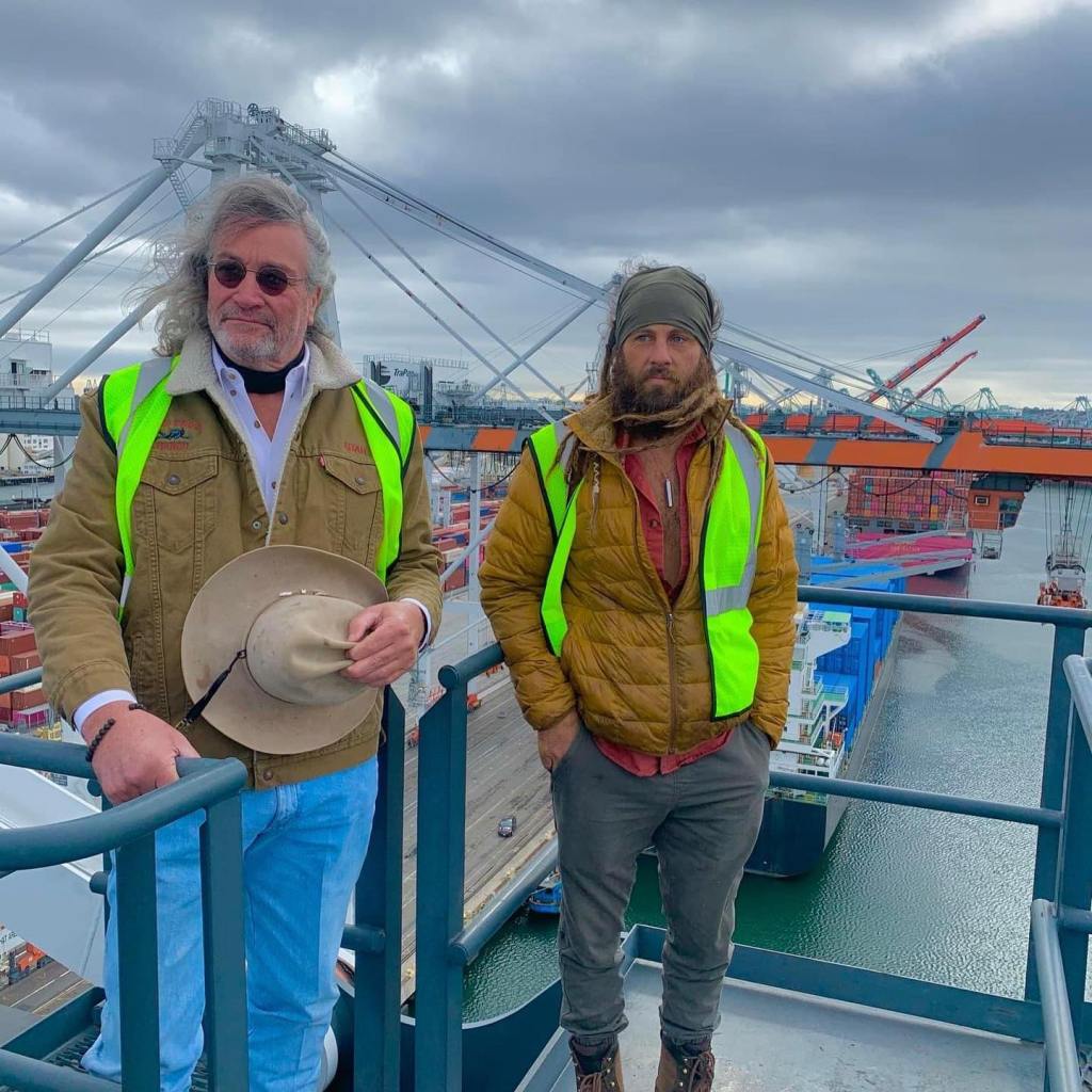 Duane and Chad Ollinger wearing reflective vests at a shipping port.