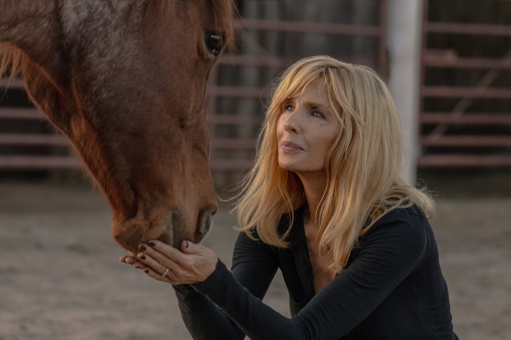 Kelly Reilly as Beth Dutton petting a horse.