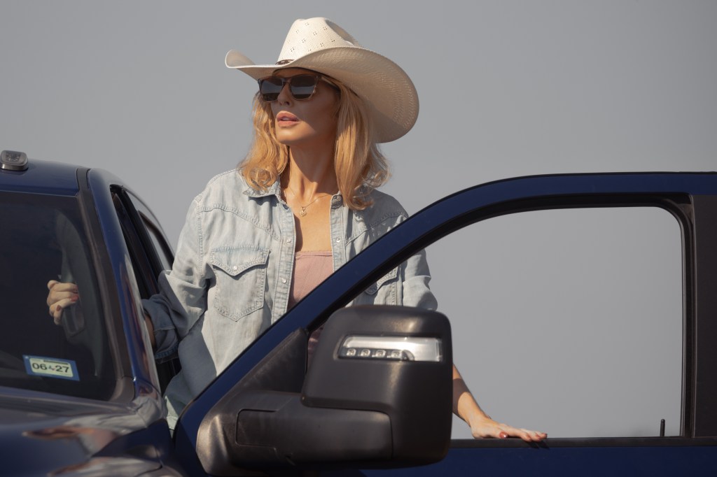 Kelly Reilly as Beth Dutton in Dutton Ranch, looking out from a truck wearing a cowboy hat and sunglasses.