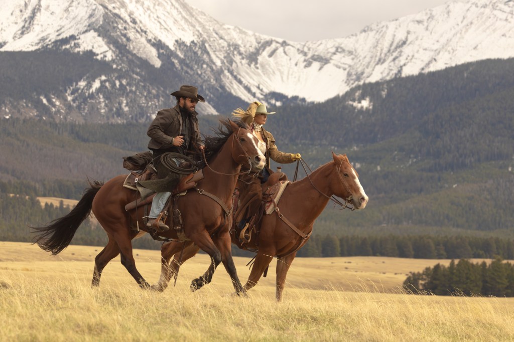 Cole Hauser as Rip Wheeler and Kelly Reilly as Beth Dutton riding horses in a field with snow-capped mountains in the background.