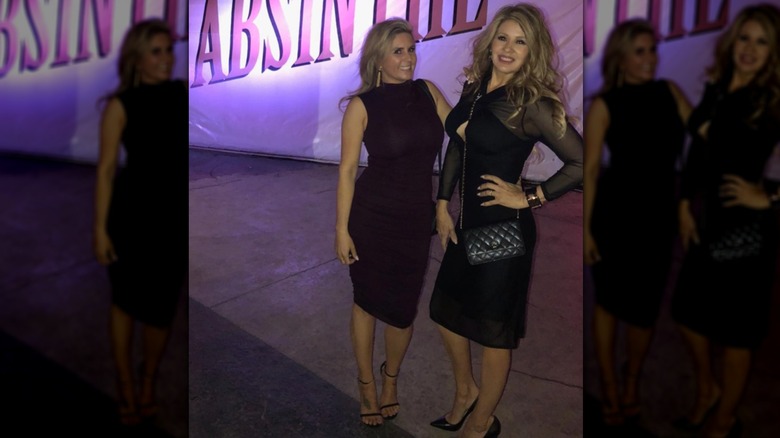 Brandi Passante (L) poses in a burgundy dress next to a female friend (R)